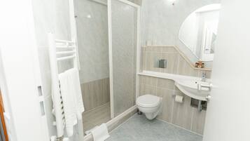 Un baño moderno con ducha, inodoro y lavabo.