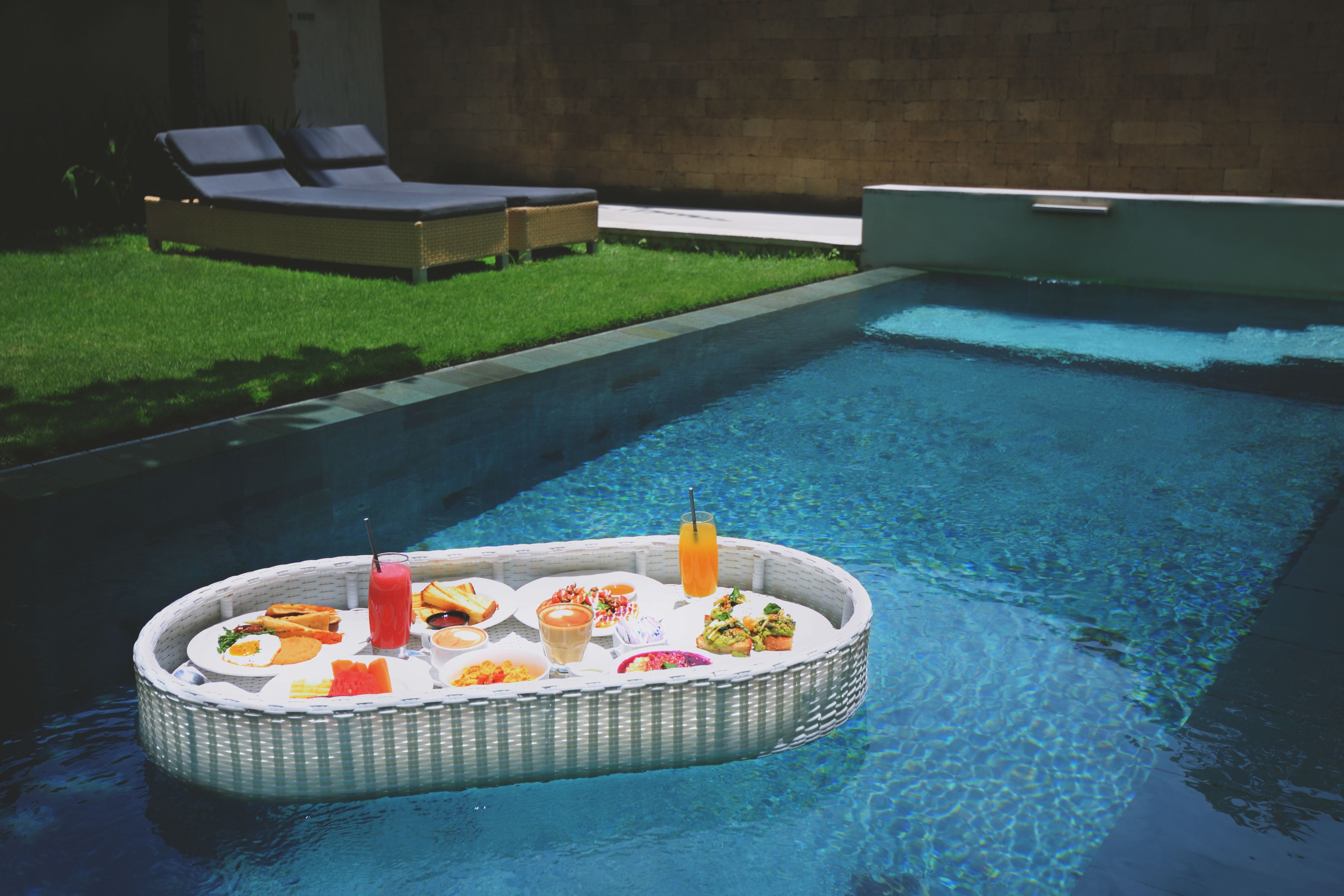 A poolside area with a floating dining table.