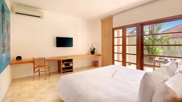 Un dormitorio con cama, escritorio, silla, televisor y ventana con vista al exterior.