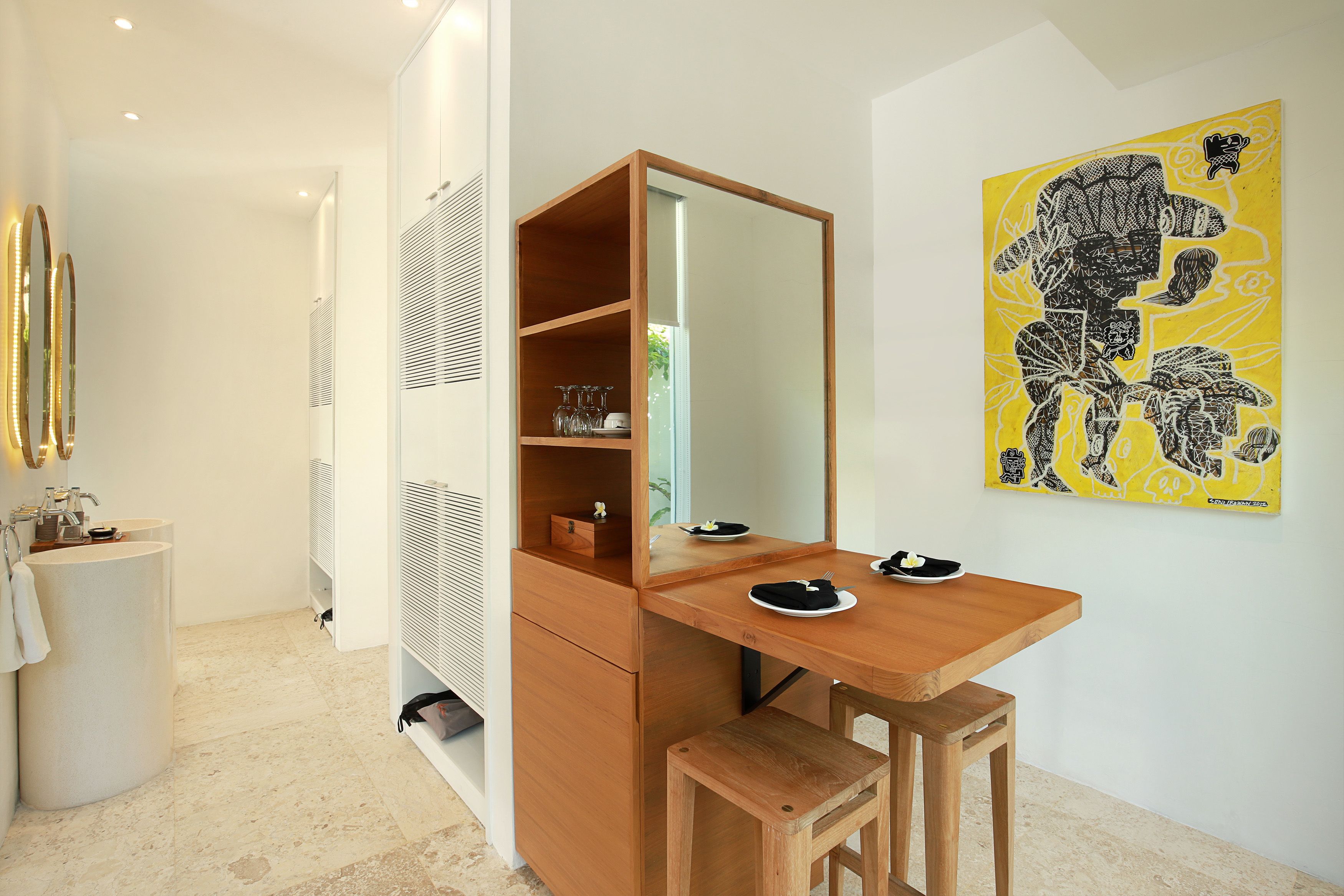 A modern bathroom with a wooden vanity, a mirror, and a yellow artwork on the wall.