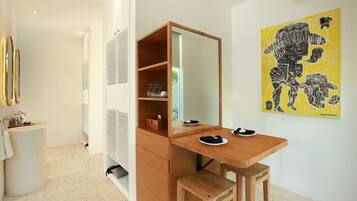A modern bathroom with a wooden vanity, a mirror, and a yellow artwork on the wall.