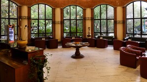 Una habitación amplia con techo alto, ventanas grandes y un candelabro.