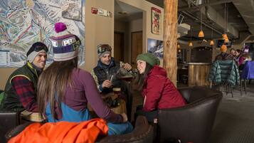 Relax in a cozy lounge area with leather chairs and tables, surrounded by a large map and exposed wooden beams.