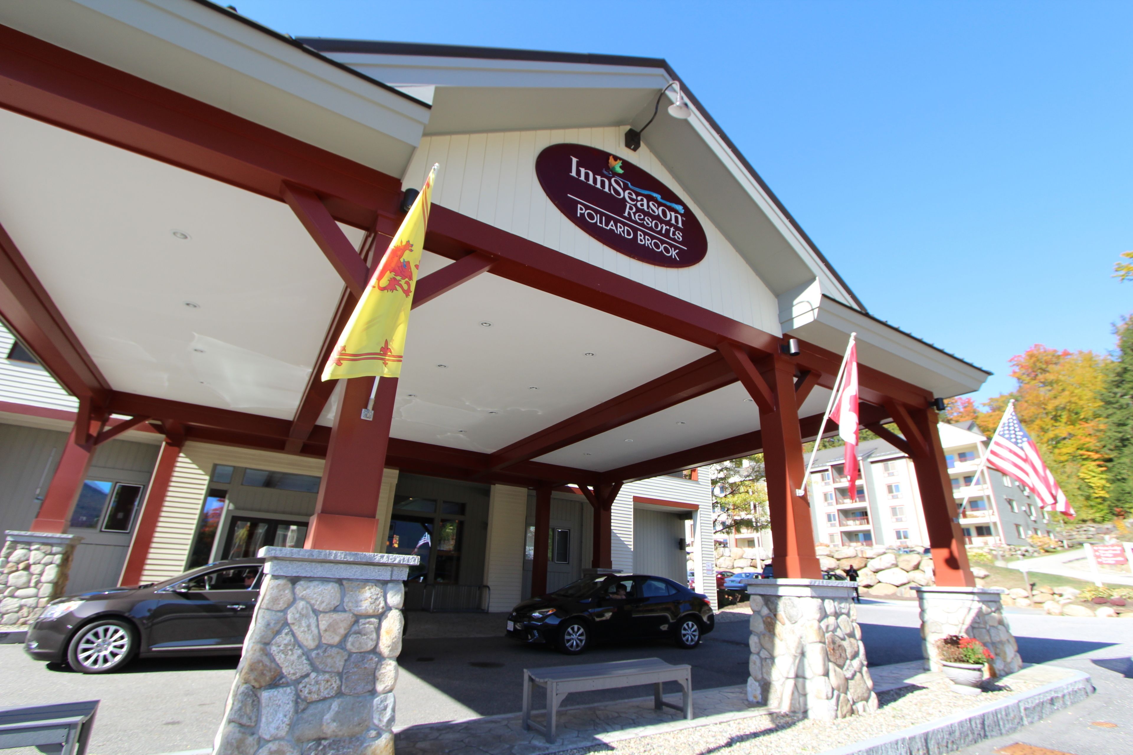 L’extérieur des complexes InnSeason Resorts se caractérise par une entrée abritée, des piliers en pierre et des drapeaux américains.