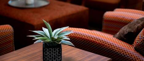 A cozy seating area with patterned orange sofas and a wooden coffee table.