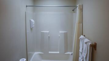 A bathroom with a skylight, a bathtub, a toilet, and a towel rack.