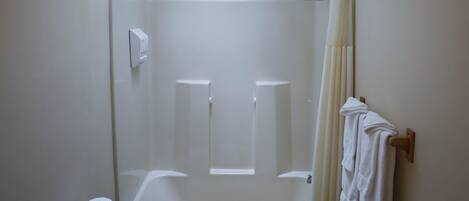 A bathroom with a skylight, a bathtub, a toilet, and a towel rack.