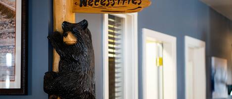 A wooden sign with a bear holding a sign that reads "Bear Necessities."