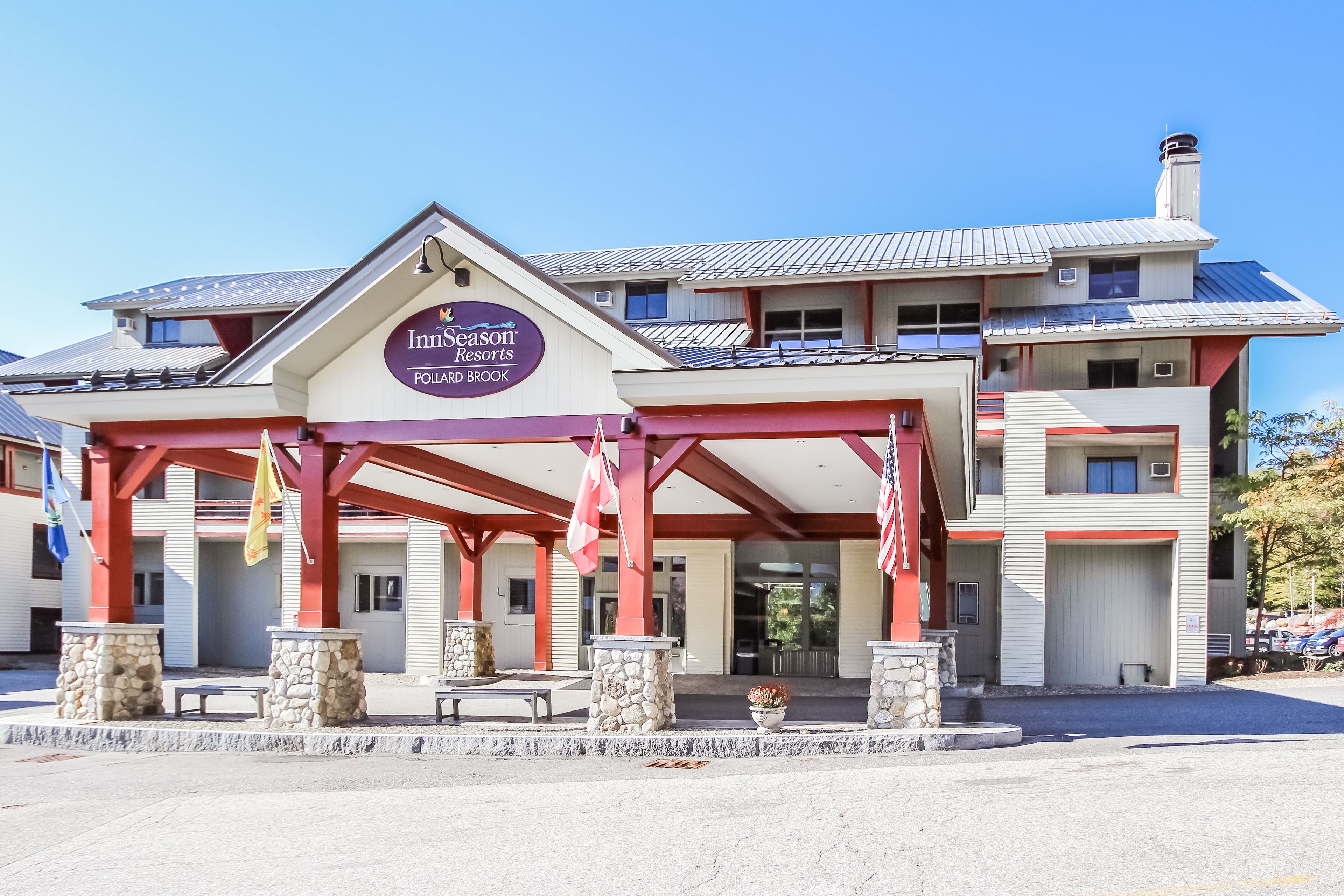 Ein Hotel mit überdachter Eingangspartie, steinernen Säulen und einem Schild mit der Aufschrift "Inns of the Pollard Brook".