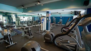 A gym with various exercise equipment including treadmills, elliptical machines, and weight machines.