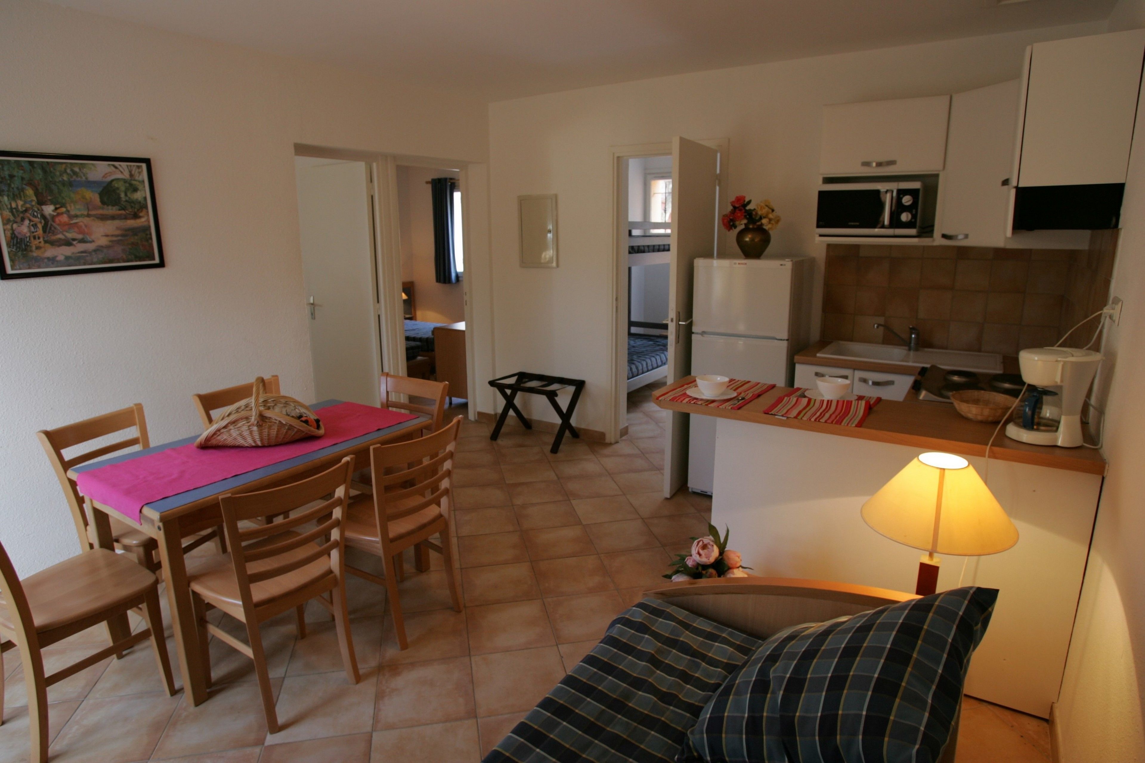 Un espacio habitable compacto con comedor, kitchenette y sofá.