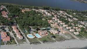 Vista aérea de una zona residencial costera con casas, una playa y una piscina.