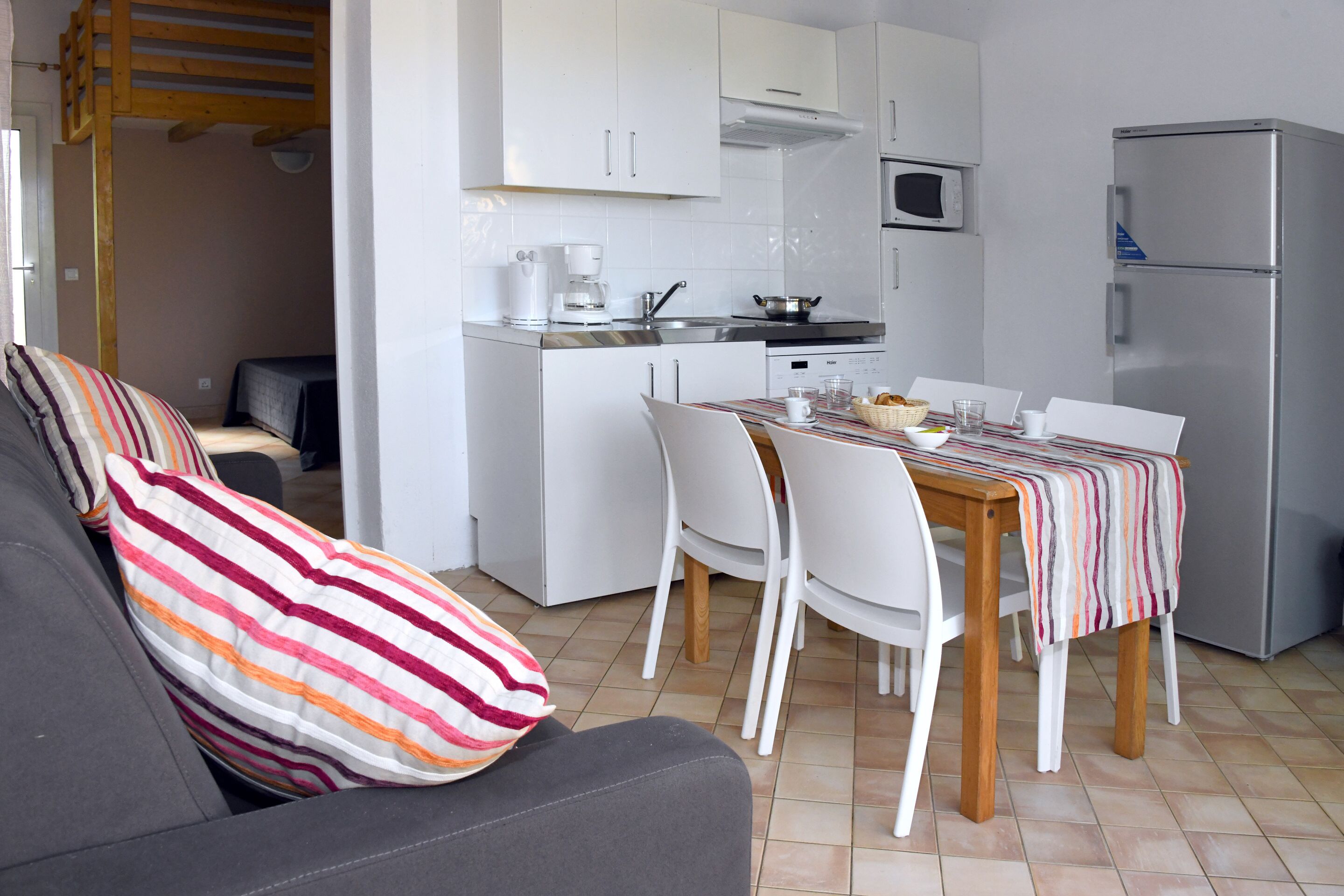 A compact kitchen with white cabinets, a microwave, and a refrigerator.