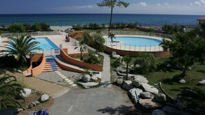 Un resort con dos piscinas, una playa y vistas al océano.
