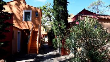 A narrow alleyway between buildings with a staircase leading to a door.