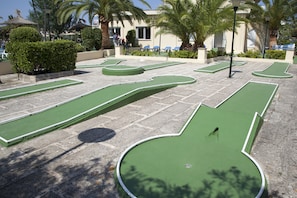 A miniature golf course with multiple green holes and a stone pathway. - Grupotel Amapola (Muro)