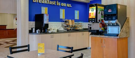 A breakfast area with a counter, seating, and a coffee machine.