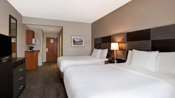 Een hotelkamer met twee bedden, een televisie, een bureau en een badkamer.