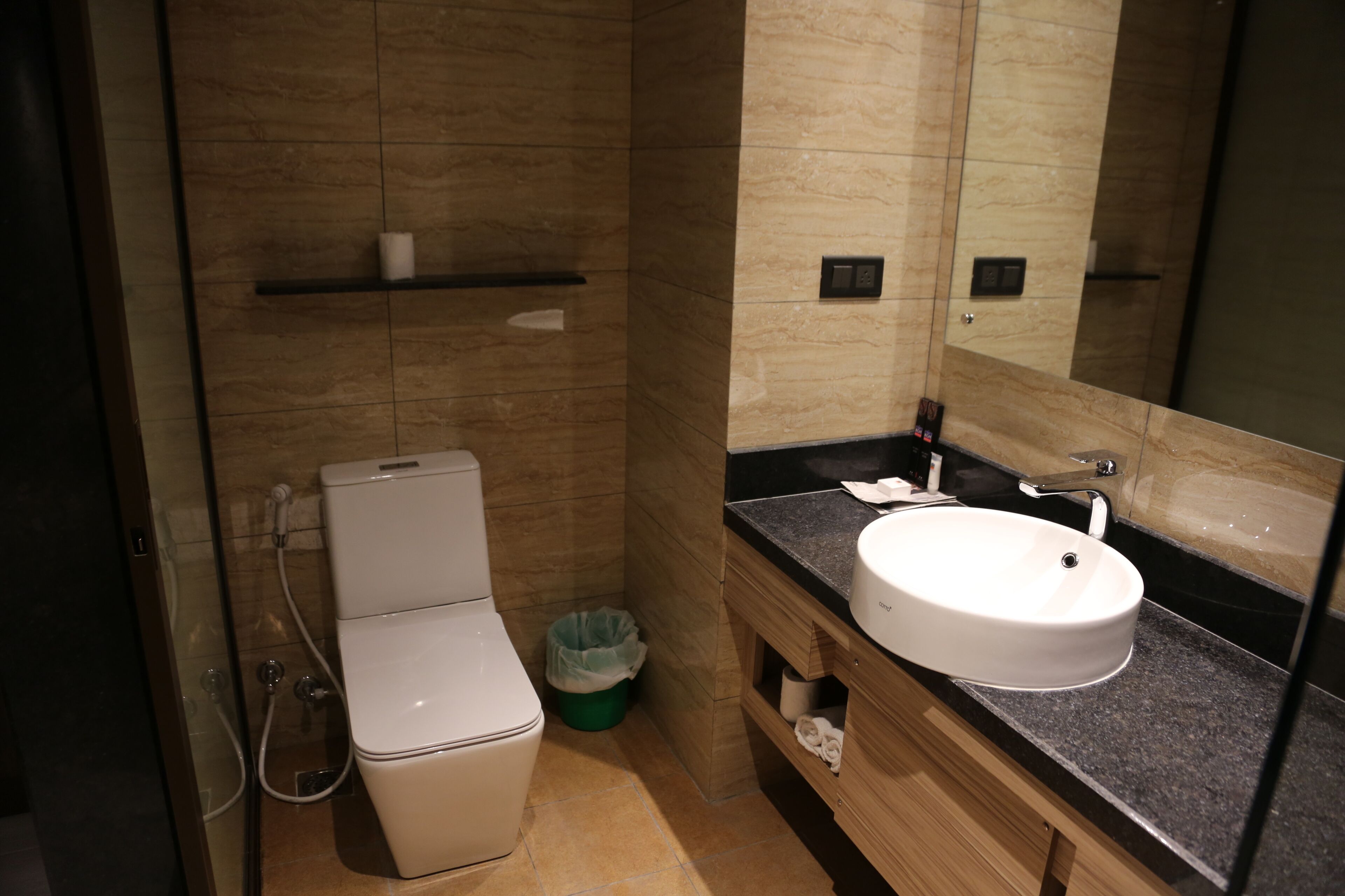 Ein modernes Badezimmer mit Toilette, Waschbecken und Spiegel.