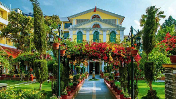 A grand building with a central entrance, flanked by symmetrical gardens and pathways. - Kathmandu Guest House by KGH Group (Kathmandu)