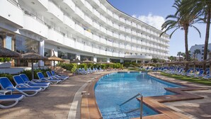 A hotel with a swimming pool, sun loungers, and a palm tree. - Grupotel Maritimo (Alcúdia)
