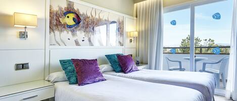 Una habitación de hotel con dos camas, un escritorio y un balcón con sillas.