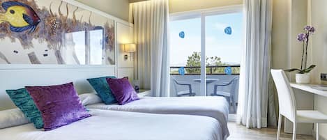 A hotel room with two beds, a balcony with a view, and a desk with a chair.