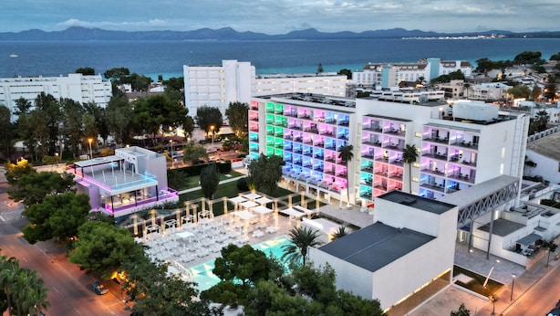 Un hôtel à plusieurs étages, doté d’une piscine extérieure et offrant une vue sur la mer.
