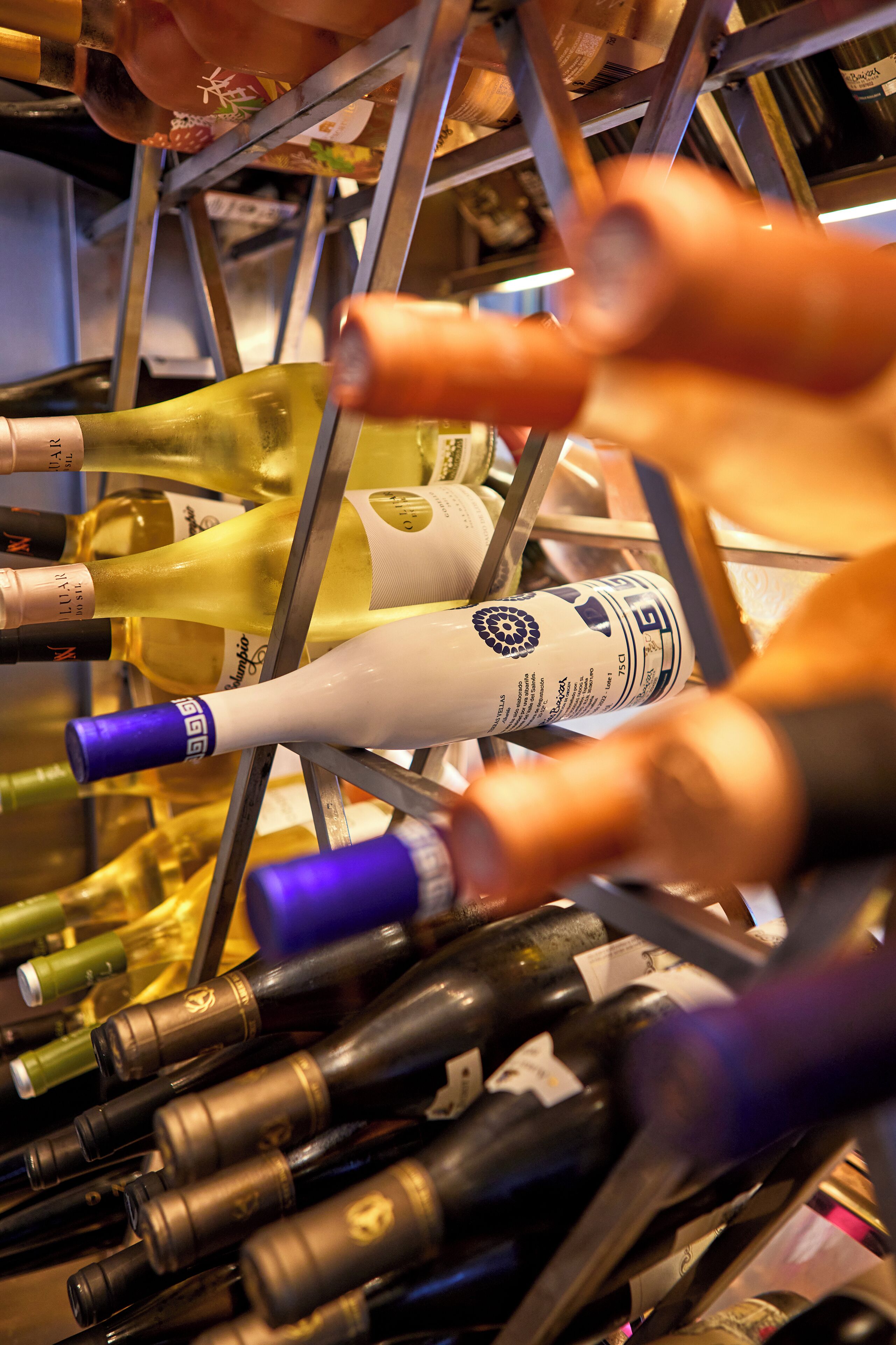 Varias botellas de vino en un estante metálico.