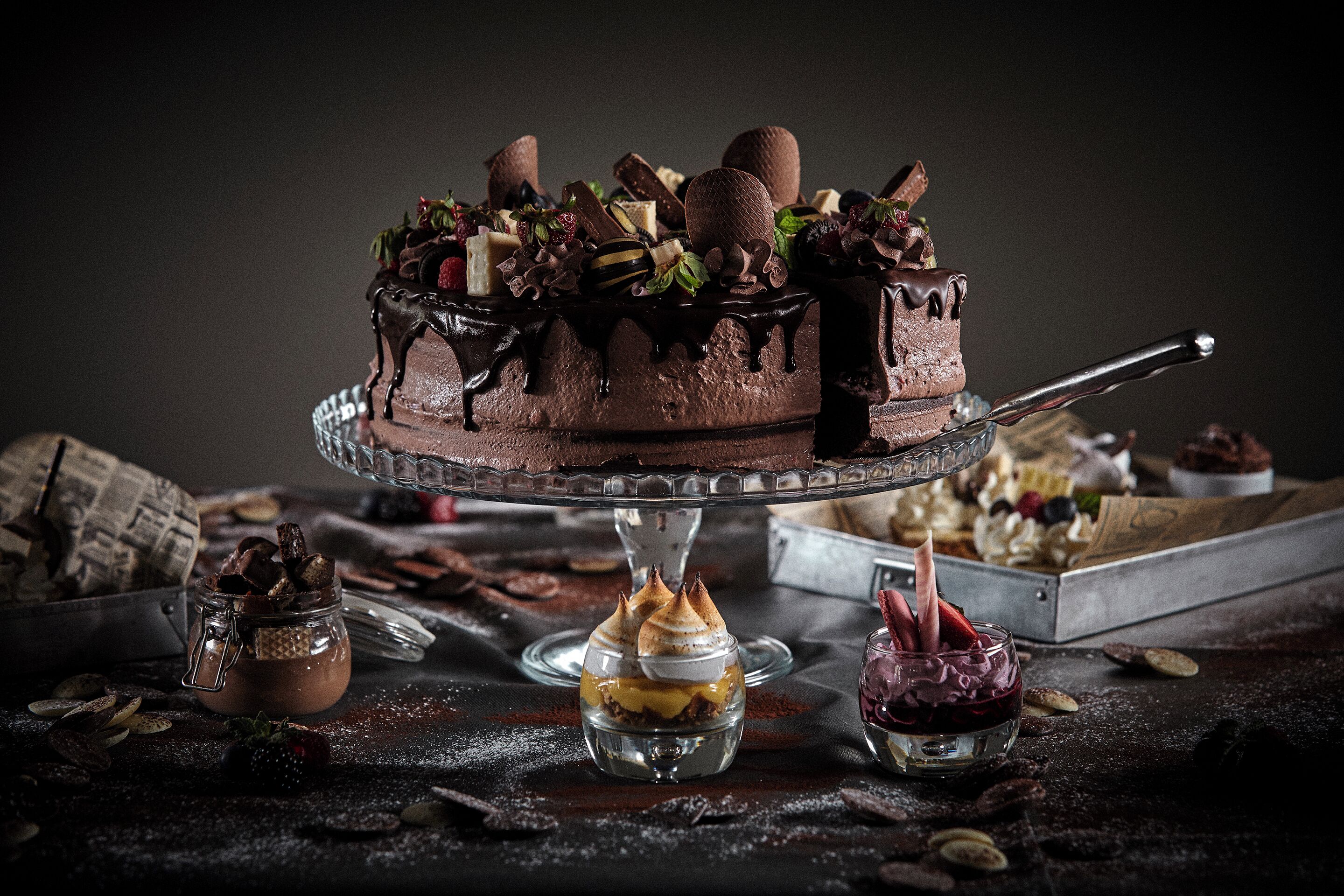 A chocolate cake with decorative elements on a glass stand.