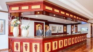 A reception desk with two staff members, a marble floor, and framed artwork on the walls. - Grupotel Santa Eulària & Spa - Adults Only (Santa Eulalia del Rio)