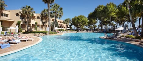 Una piscina cubierta, una piscina al aire libre, sombrillas, tumbonas