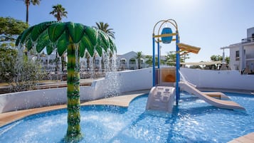 Una piscina con tobogán y una decoración de palmera.