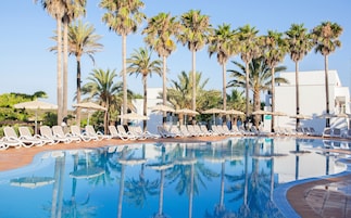 Una piscina al aire libre, sombrillas, tumbonas