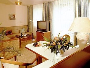 Quarto casal superior, 1 cama King | Área de estar | TV