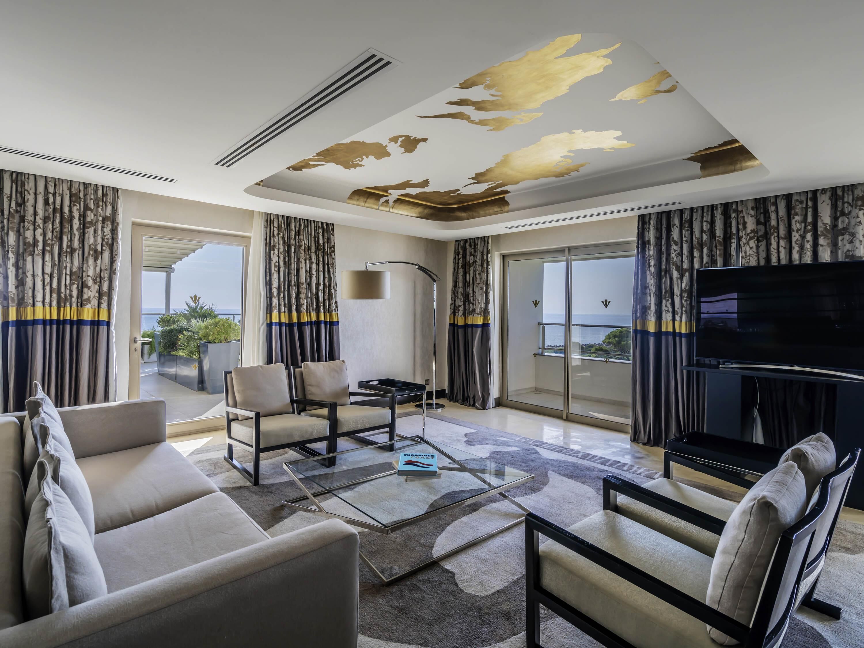 A modern living room with a sofa, chairs, a coffee table, and a flat-screen TV.