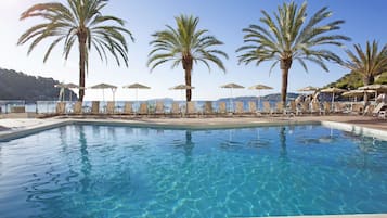 Alberca al aire libre, sombrillas en la alberca y camastros