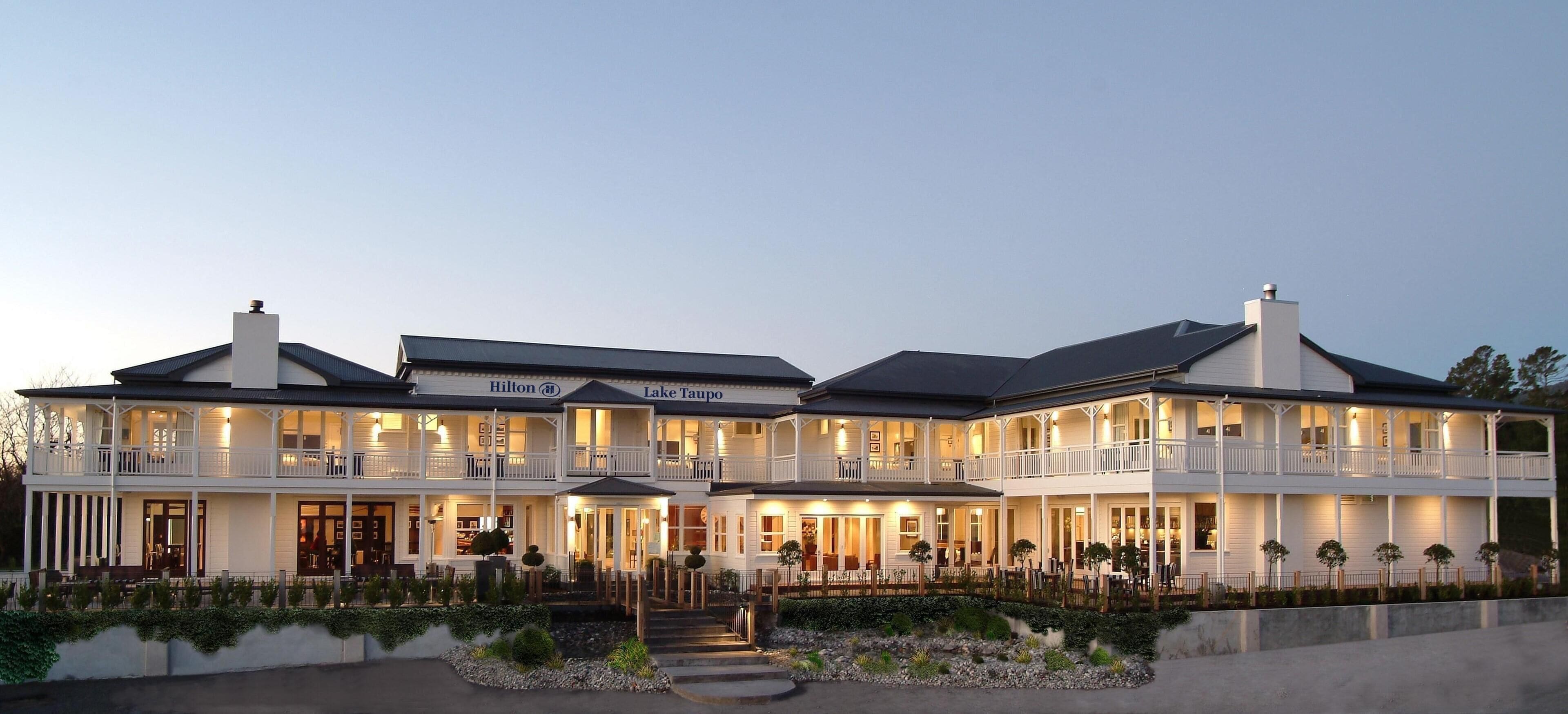 A large, two-story hotel with a prominent sign reading "Hilton Lake Tahoe."