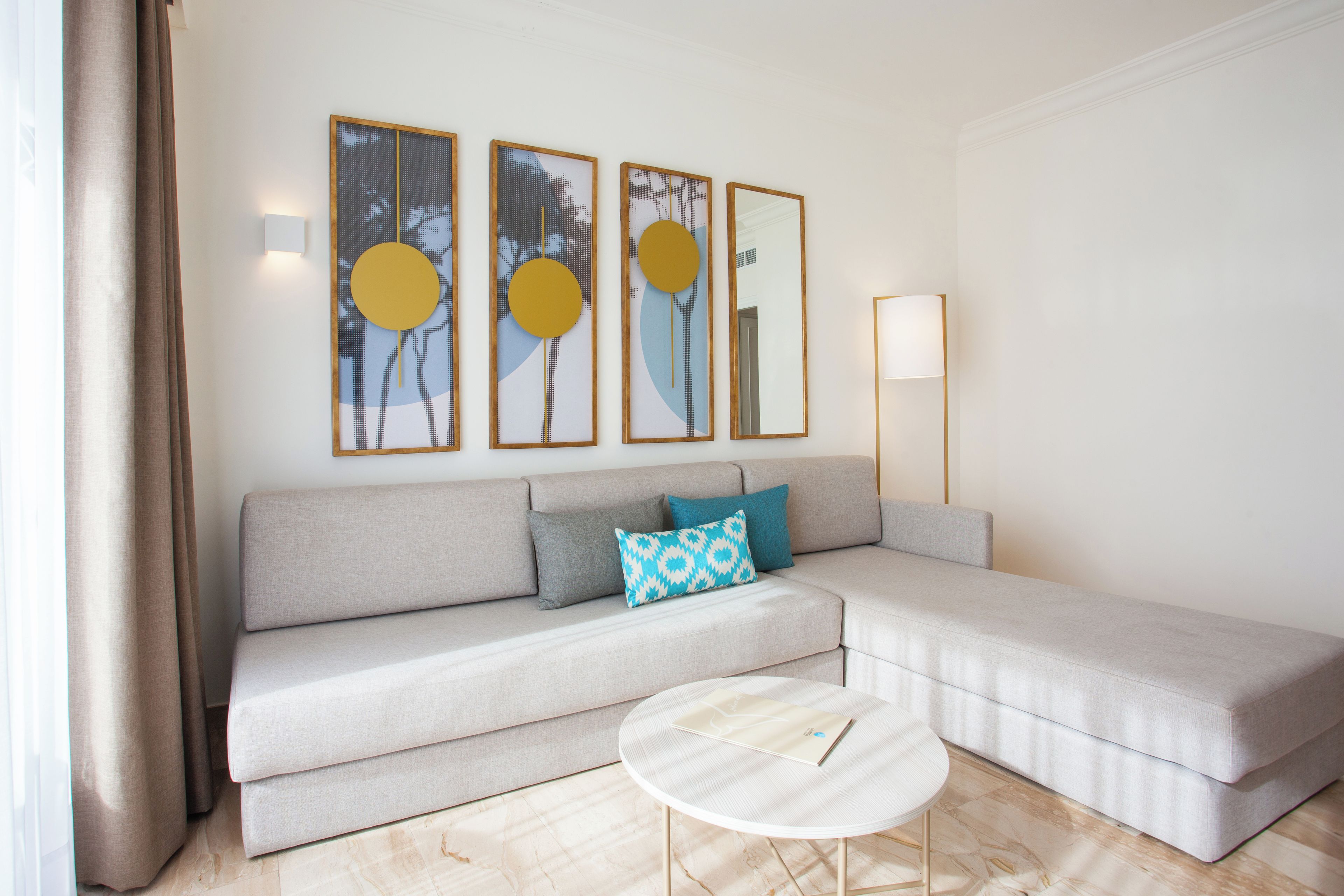 Una sala de estar moderna con sofá, una mesa de centro y obras de arte en la pared.