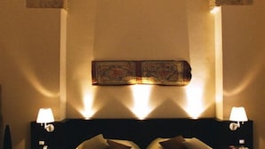 A hotel room with two beds, a decorative archway, and a wall-mounted artwork.