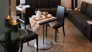 A modern dining area with a round table, chairs, and a sofa.