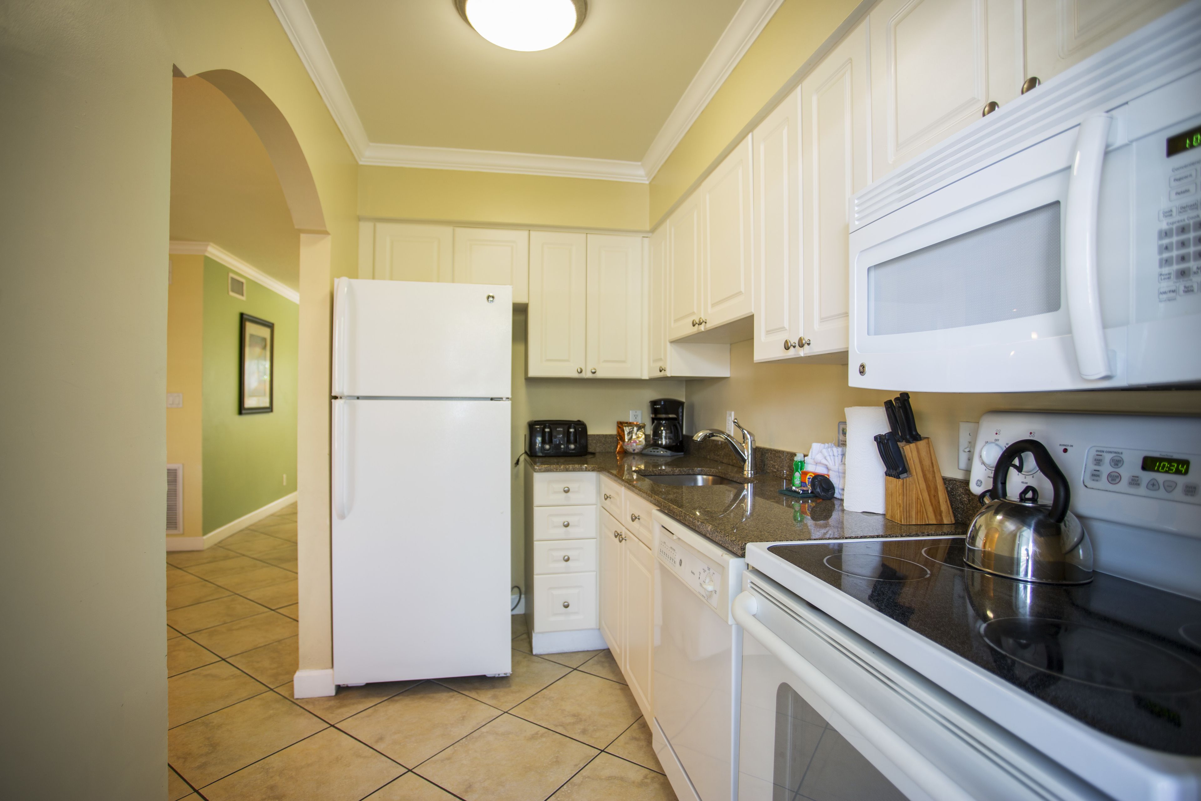 A kitchen with white cabinets, a refrigerator, a microwave, a stove, and a dishwasher.