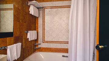 A bathroom with a bathtub, a towel rack, and a shower curtain.
