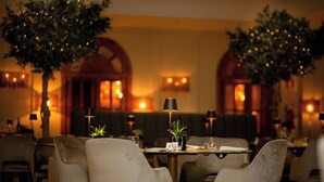 A restaurant with tables set for dining, chairs, and potted plants. - Ambasciatori Place Hotel (Fiuggi)