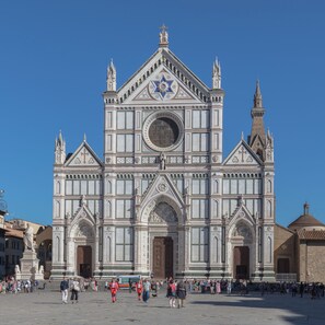 A large, ornate building with a prominent facade, large arched entrance, and multiple towers.