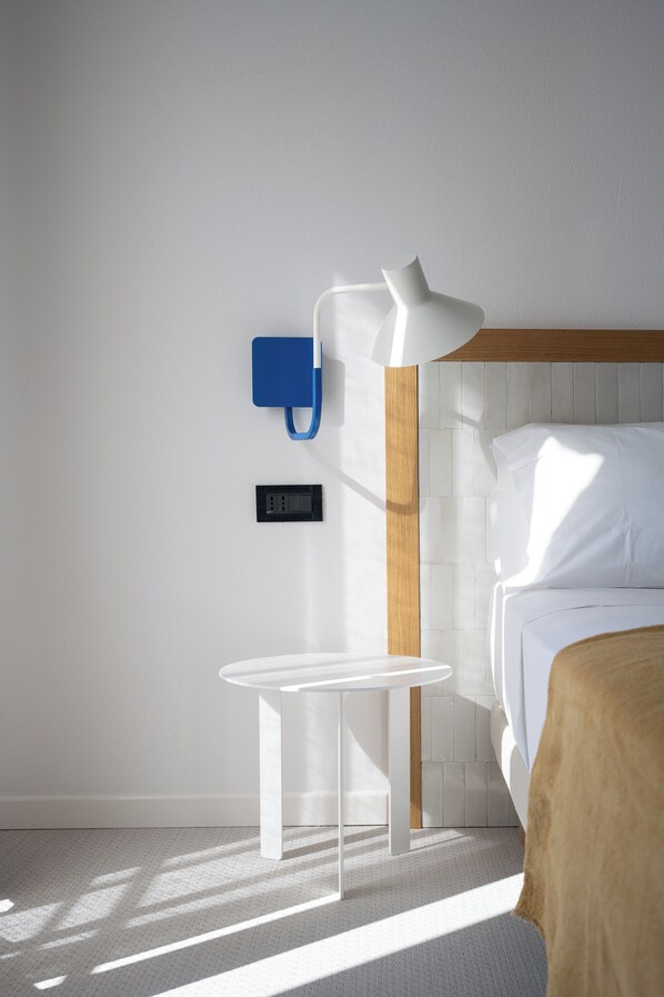 A modern hotel room with a bed, a bedside table, a lamp, and a power outlet. - Hotel Venere Azzurra (Lerici)