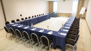 A conference room with a long table, chairs, and a whiteboard.
