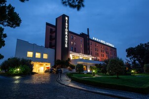 Un hotel con un llamativo letrero que dice 'Ristorante', un edificio moderno de techo plano y una entrada bien iluminada.