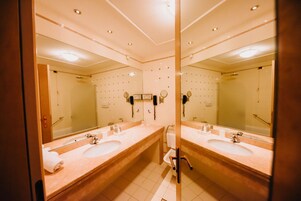 Un baño moderno con dos lavamanos, un espejo grande y una zona de ducha.