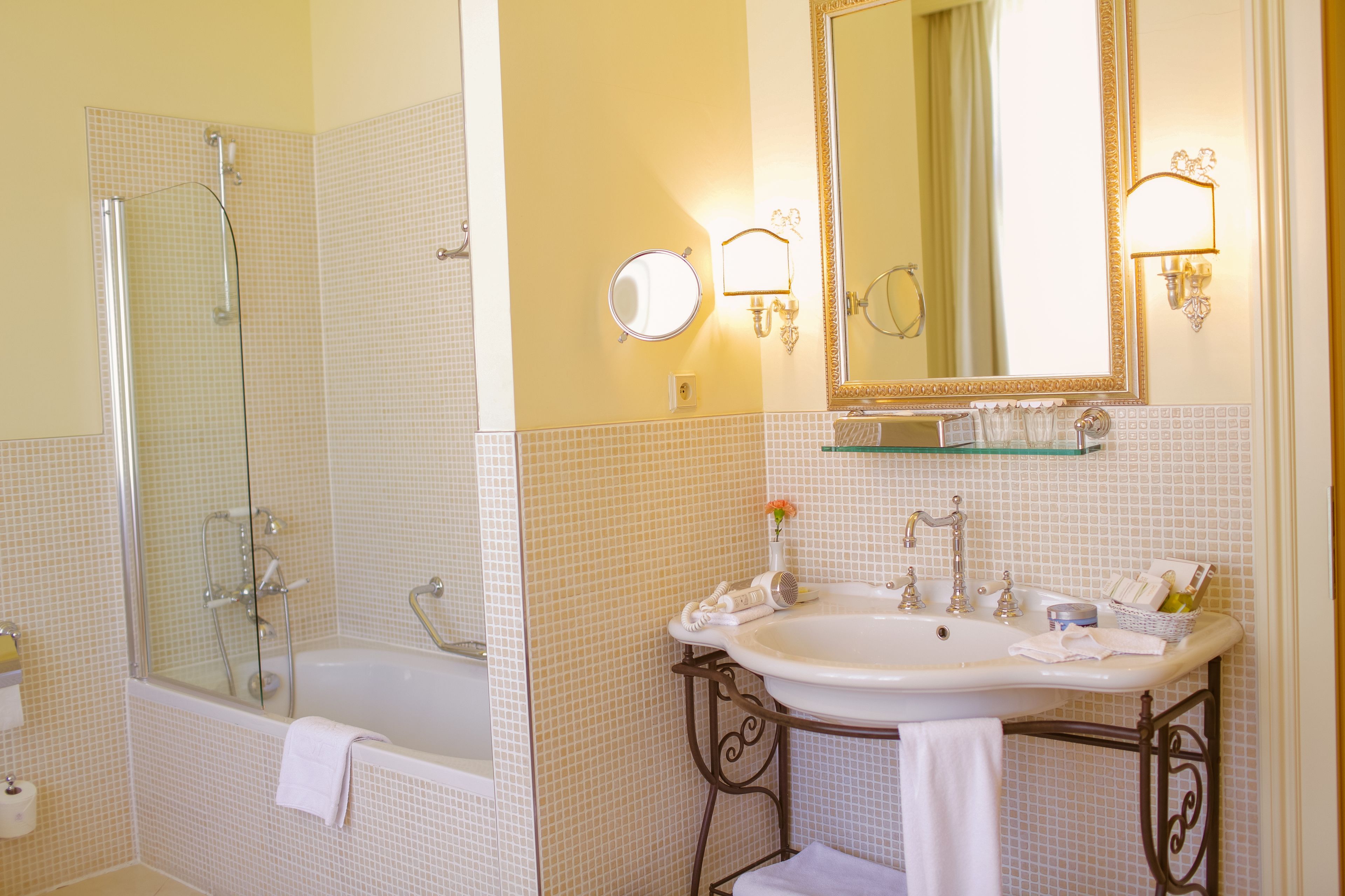 Un baño con bañera, lavamanos, espejo y ducha.